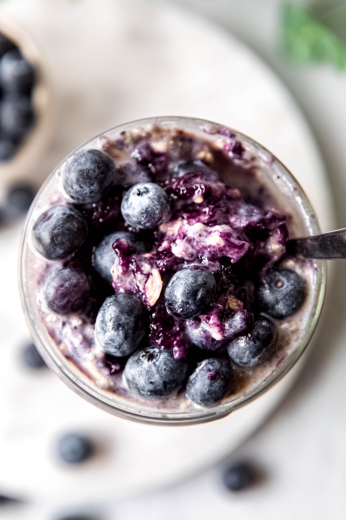 An overhead shot of a glass jar of the blueberry overnight oats.
