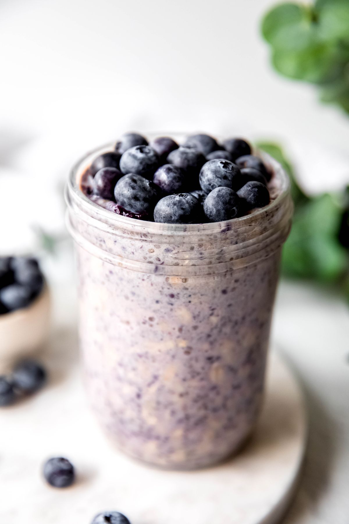 A close-up shot of a glass of blueberry overnight oats.