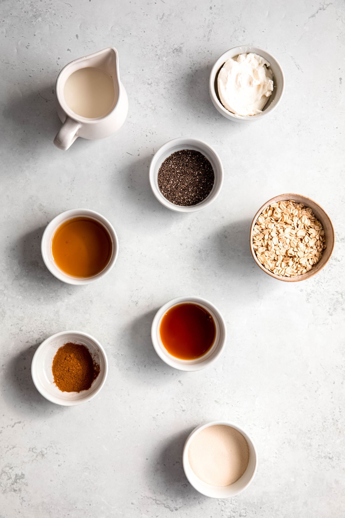 An overhead shot of all the ingredients to make high-protein cinnamon roll overnight oats.