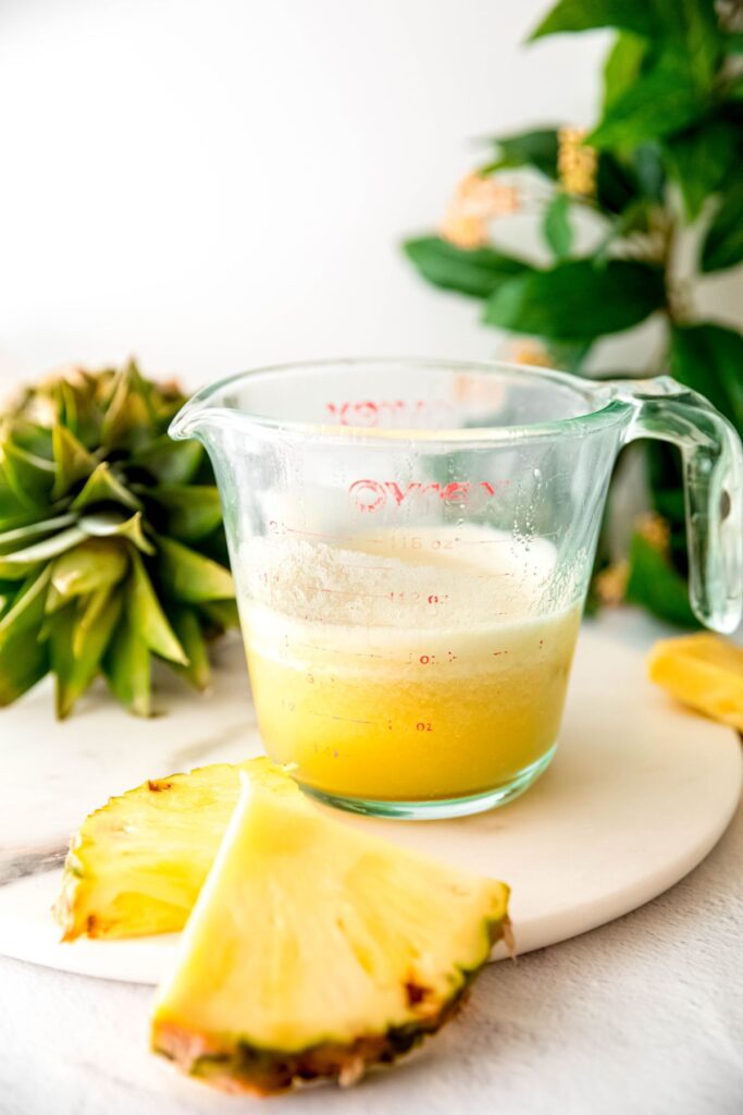 frothy strained pineapple puree in the measuring cup.