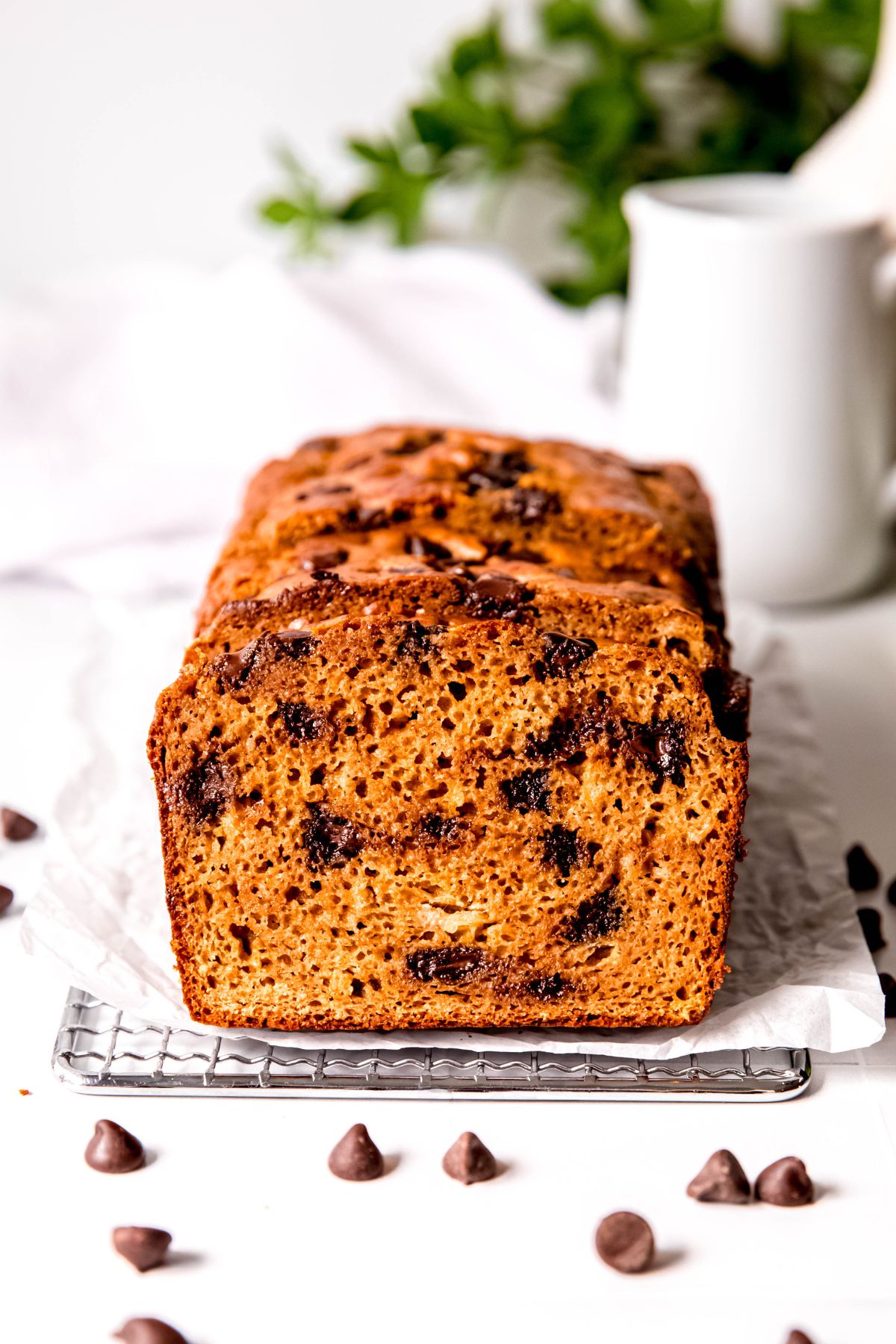 sliced loaf of high-protein banana chocolate chip bread lined up facing the camera showing the fluffy consistency of the bread and the melty pockets of chocolate chips.