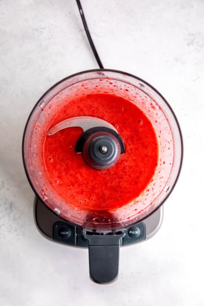 The blended strawberry vinaigrette in a food processor.