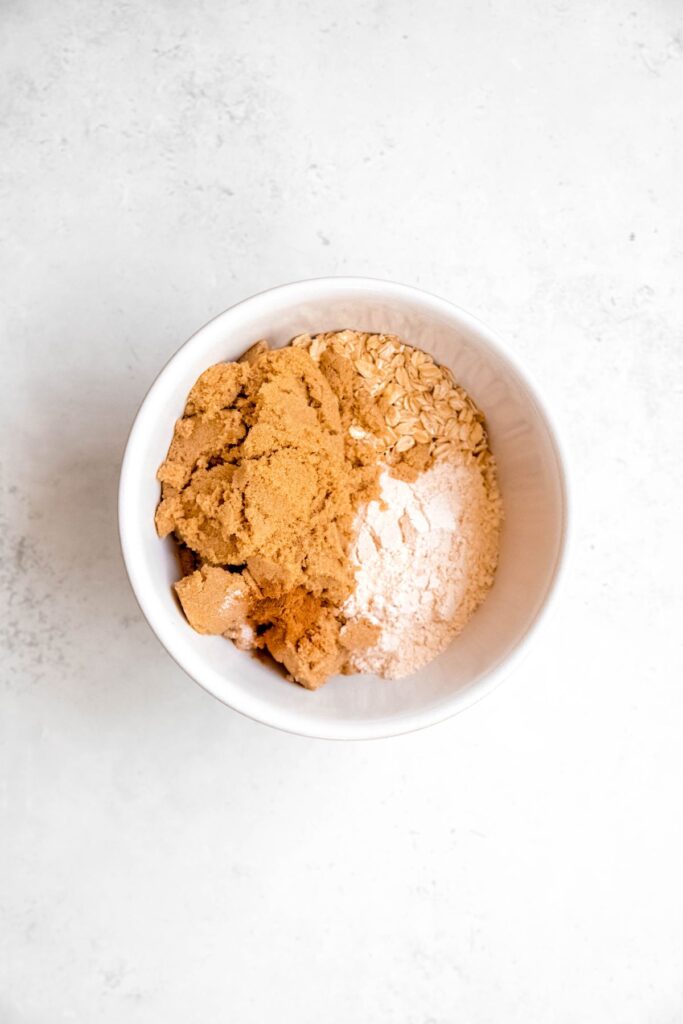 dry crisp topping ingredients added to a bowl.