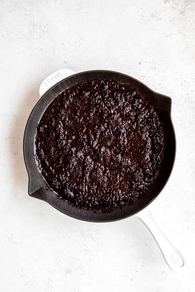 blackberry crisp filling added to a white staub cast iron skillet.