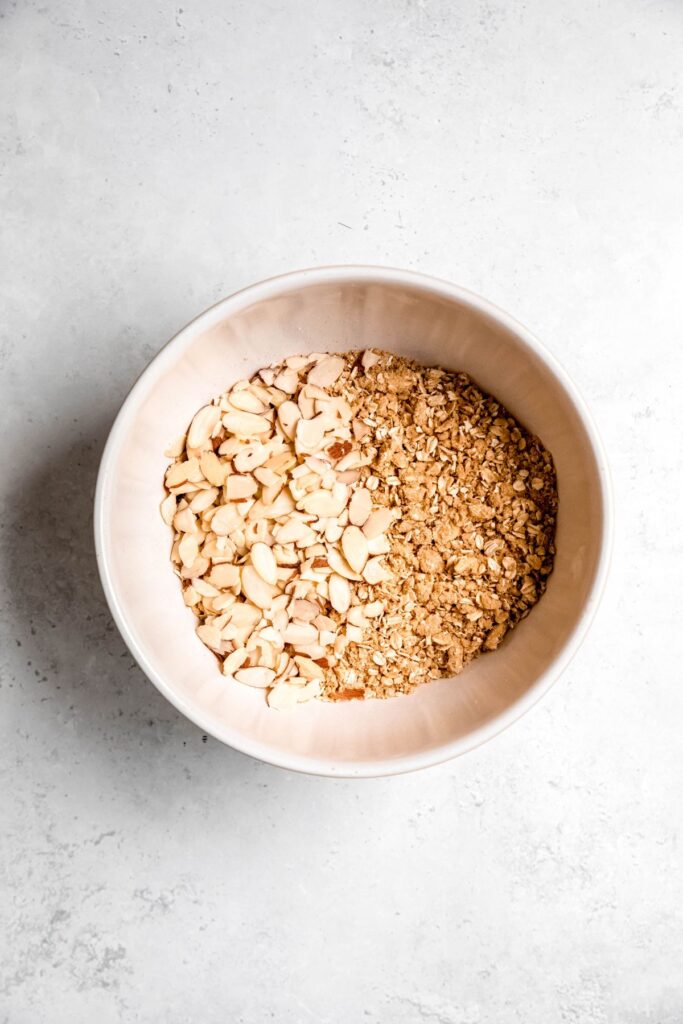 The sliced almonds added into a bowl with the dry ingredients.