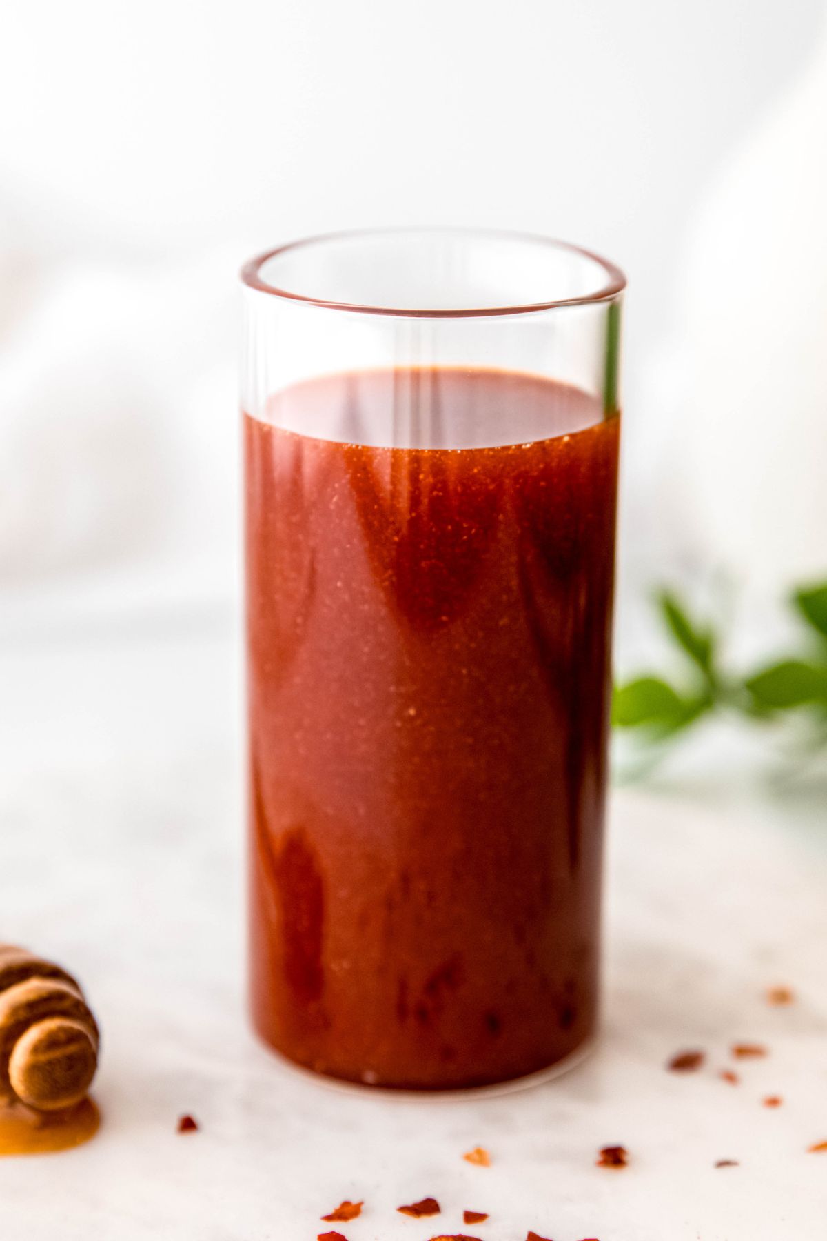 closeup shot of a collins glass filled with homemade hot honey vinaigrette for salad.