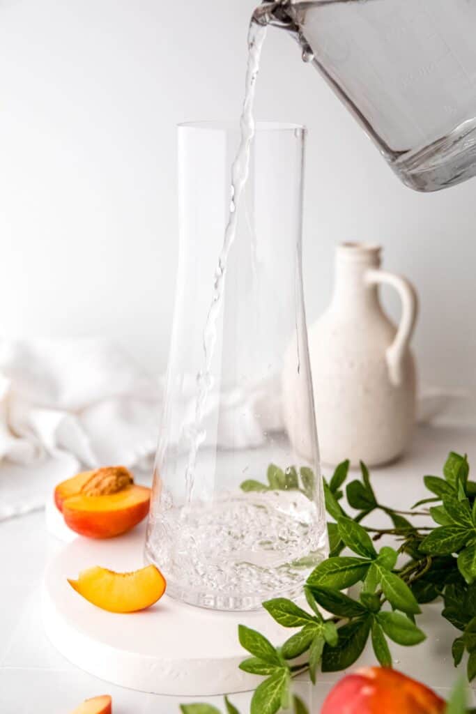 action shot of water being poured into a glass pitcher.