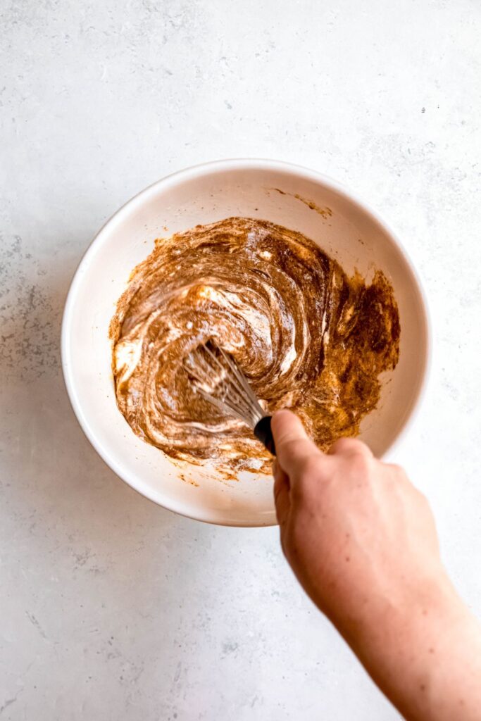 Whisking the wet ingredients in a mixing bowl.