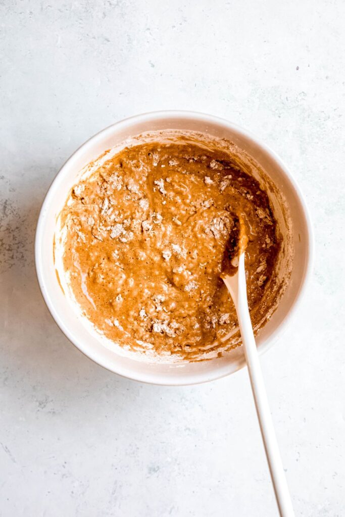 The mixed batter in a bowl with a wooden spoon.