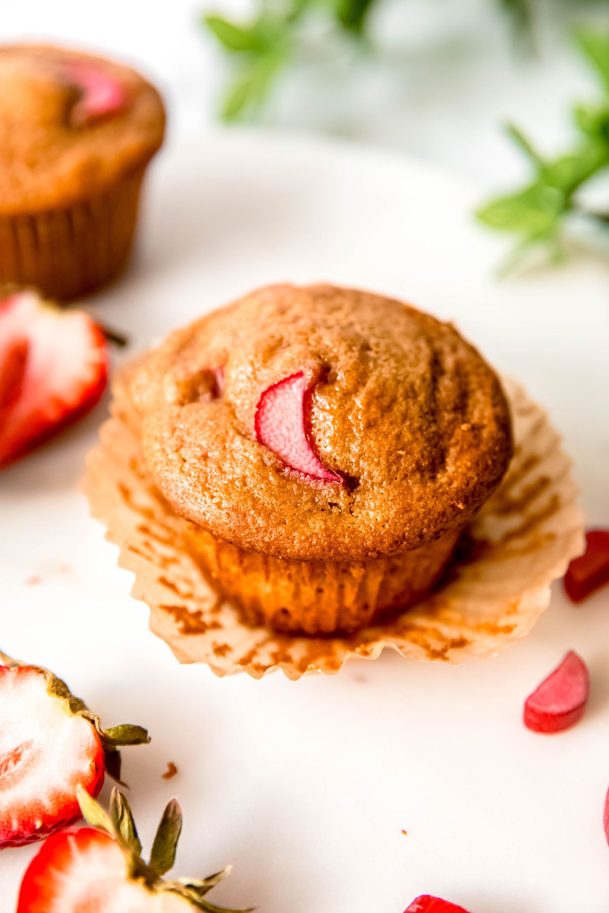 A close-up angled shot of an unwrapped strawberry rhubarb muffin