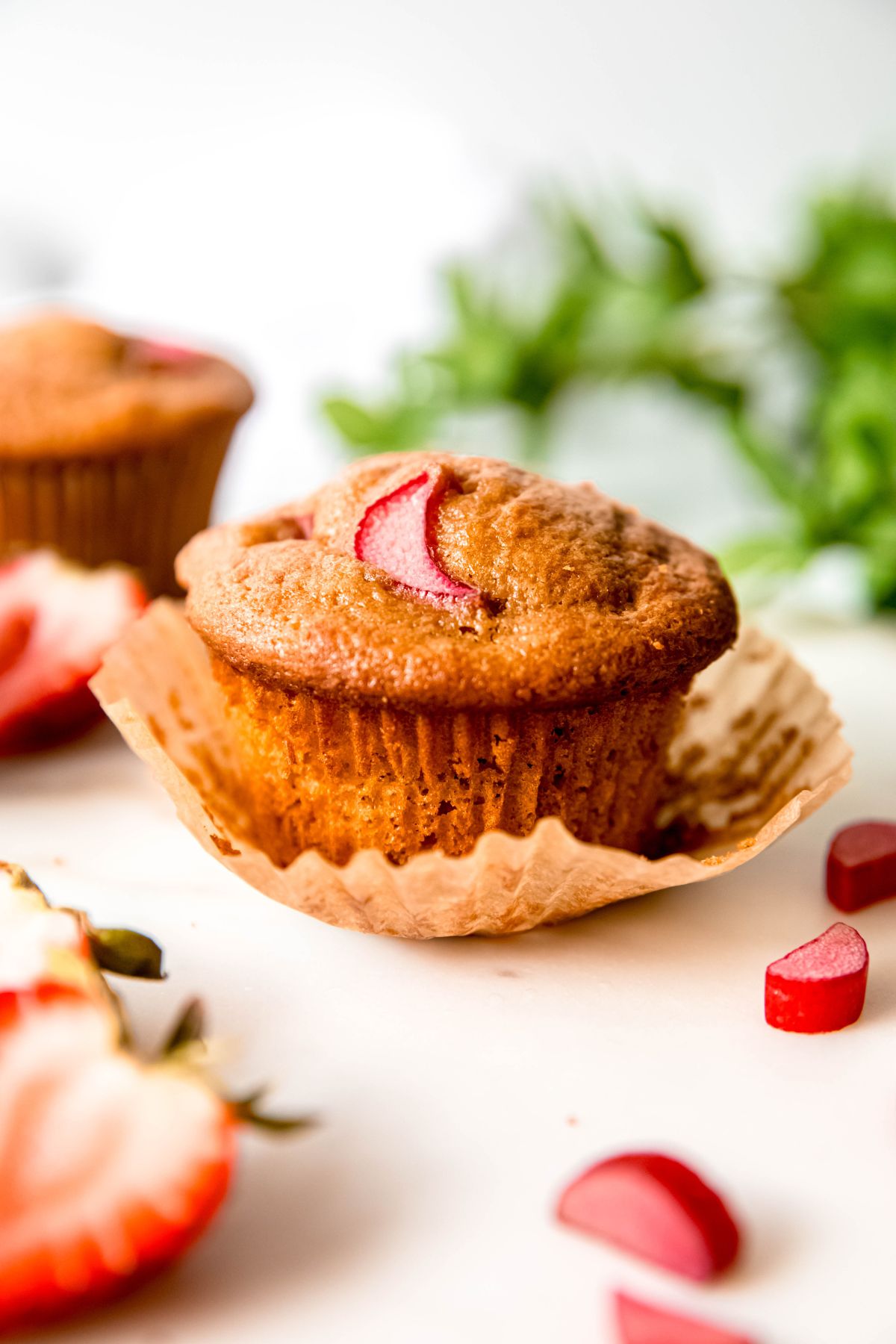 A close-up shot of an unwrapped strawberry rhubarb muffin.