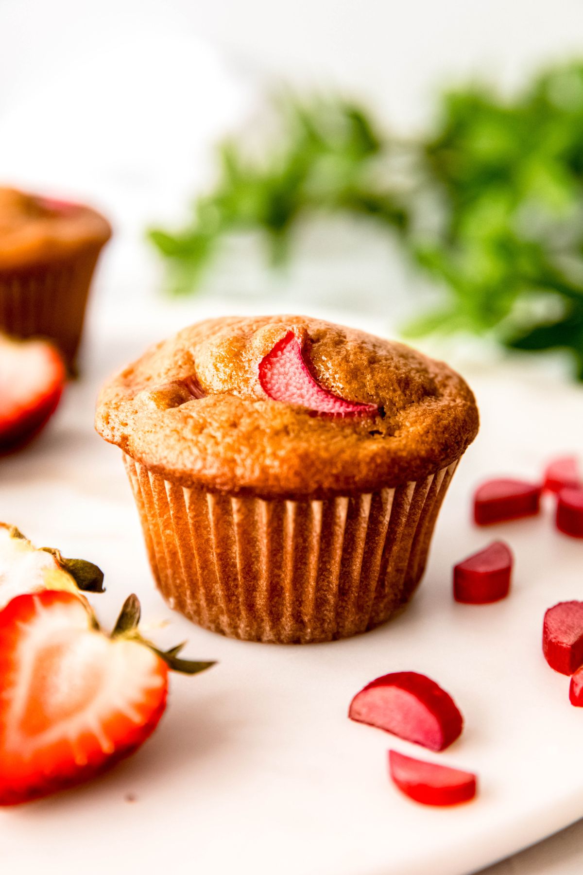 A close-up shot of a high-protein strawberry rhubarb muffin.