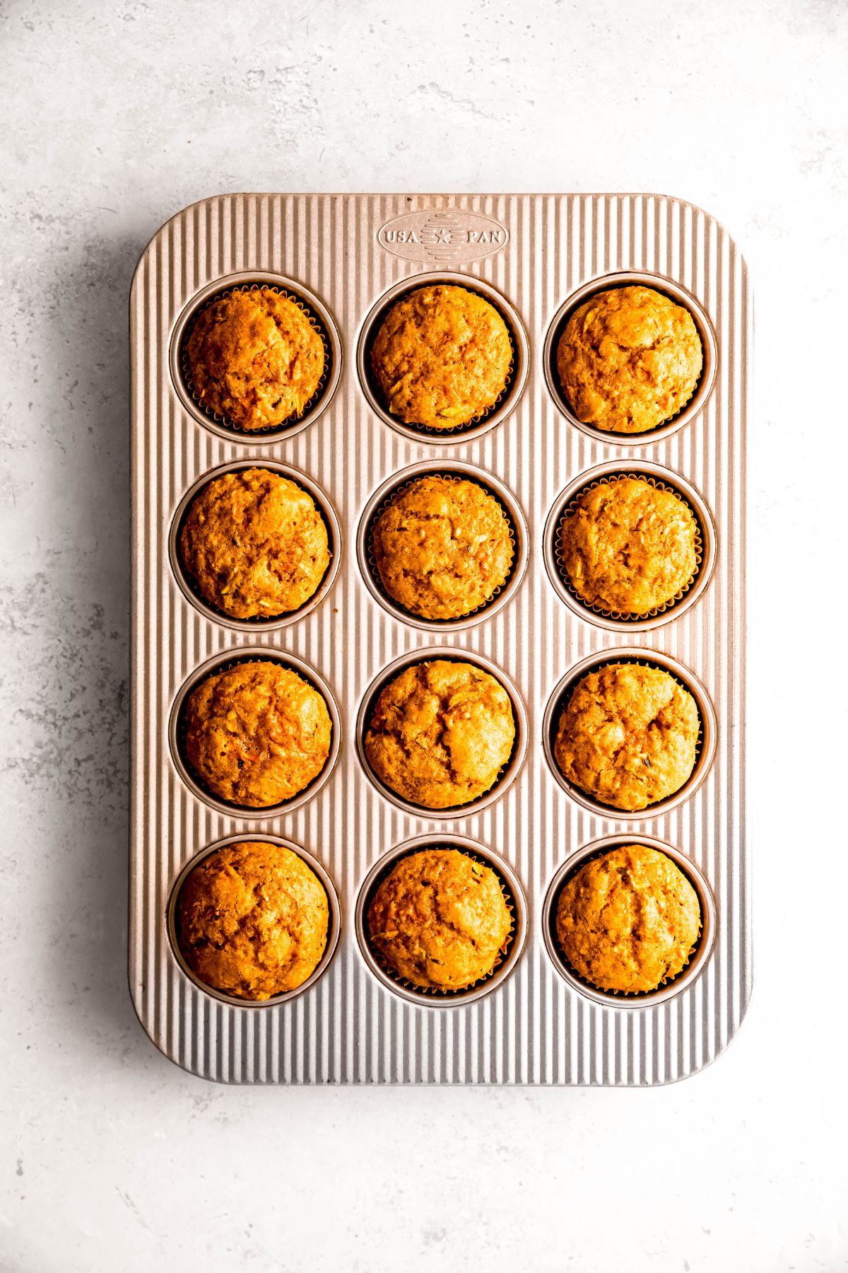 healthy carrot zucchini muffins in the muffin tray after baking.