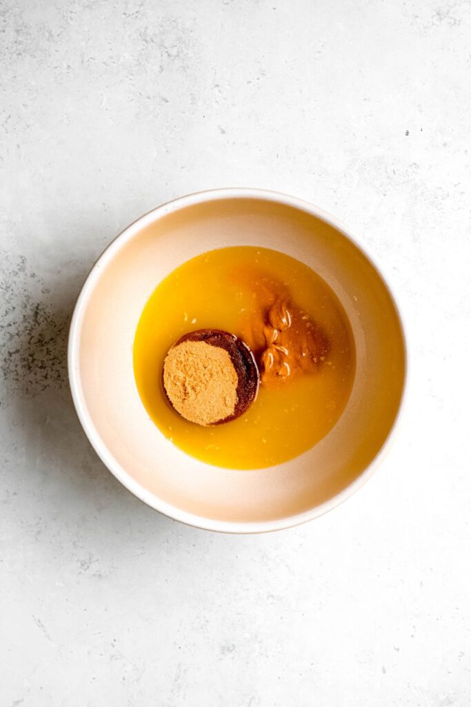 Melted butter, peanut butter, and brown sugar in a mixing bowl.
