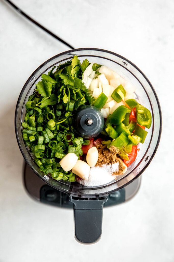 roughly chopped fresh salsa ingredients added to a food processor bowl.