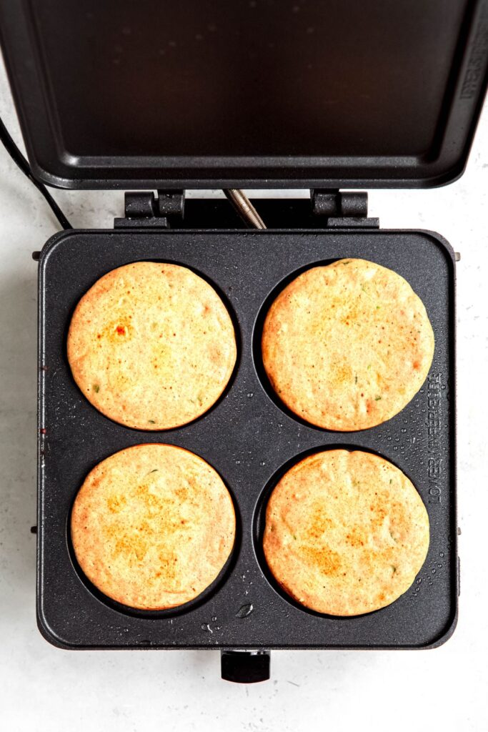 4 golden brown protein zucchini pancakes after cooking in the electric skillet.