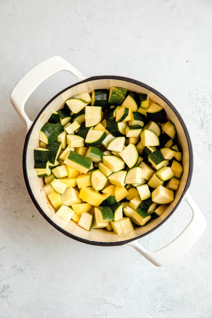 zucchini and potato cubes added to the pot with the aromatics.