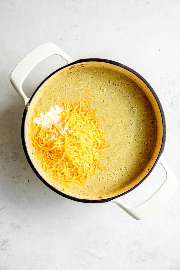 shredded cheddar cheese and cream added to the blended pot of soup.