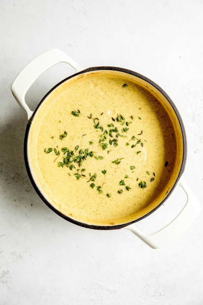 fresh thyme leaves sprinkled on top of the pot of creamy zucchini potato soup.