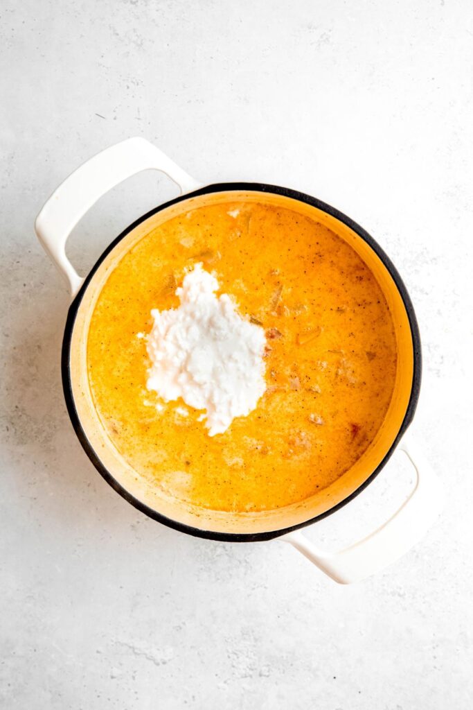 The Dutch oven with cottage cheese and simmered potato soup base.