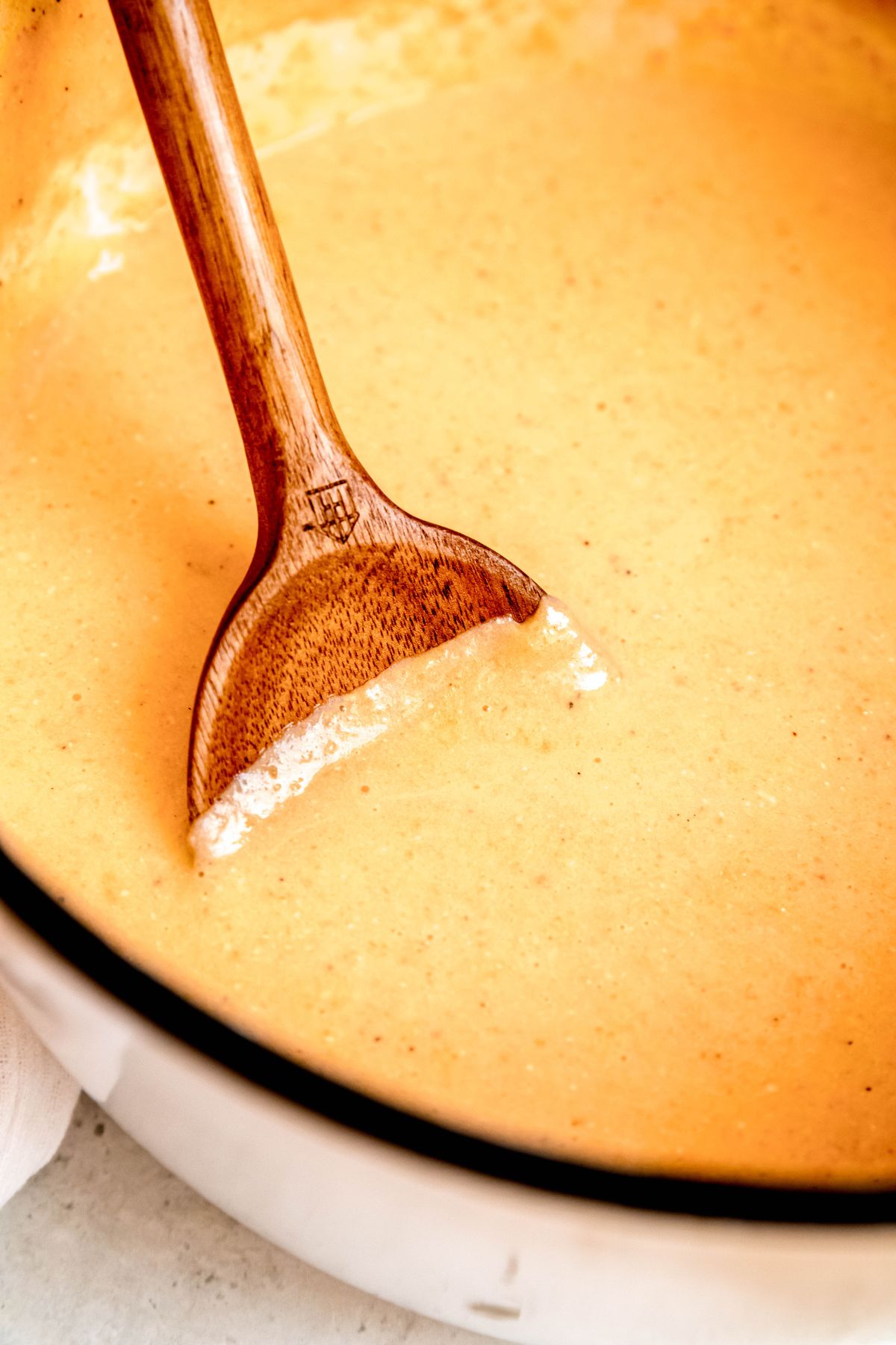 A close-up shot of a wooden spoon in the pot of high-protein potato soup.