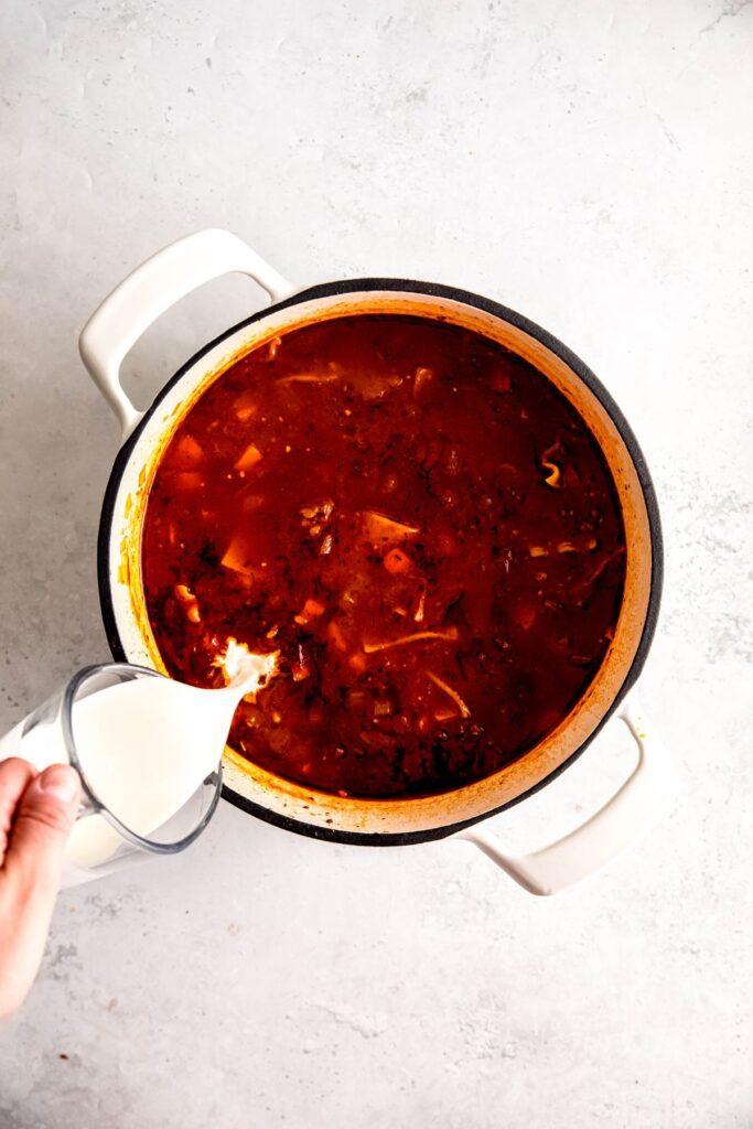 Finishing the white pot of Lasagna soup with heavy cream.
