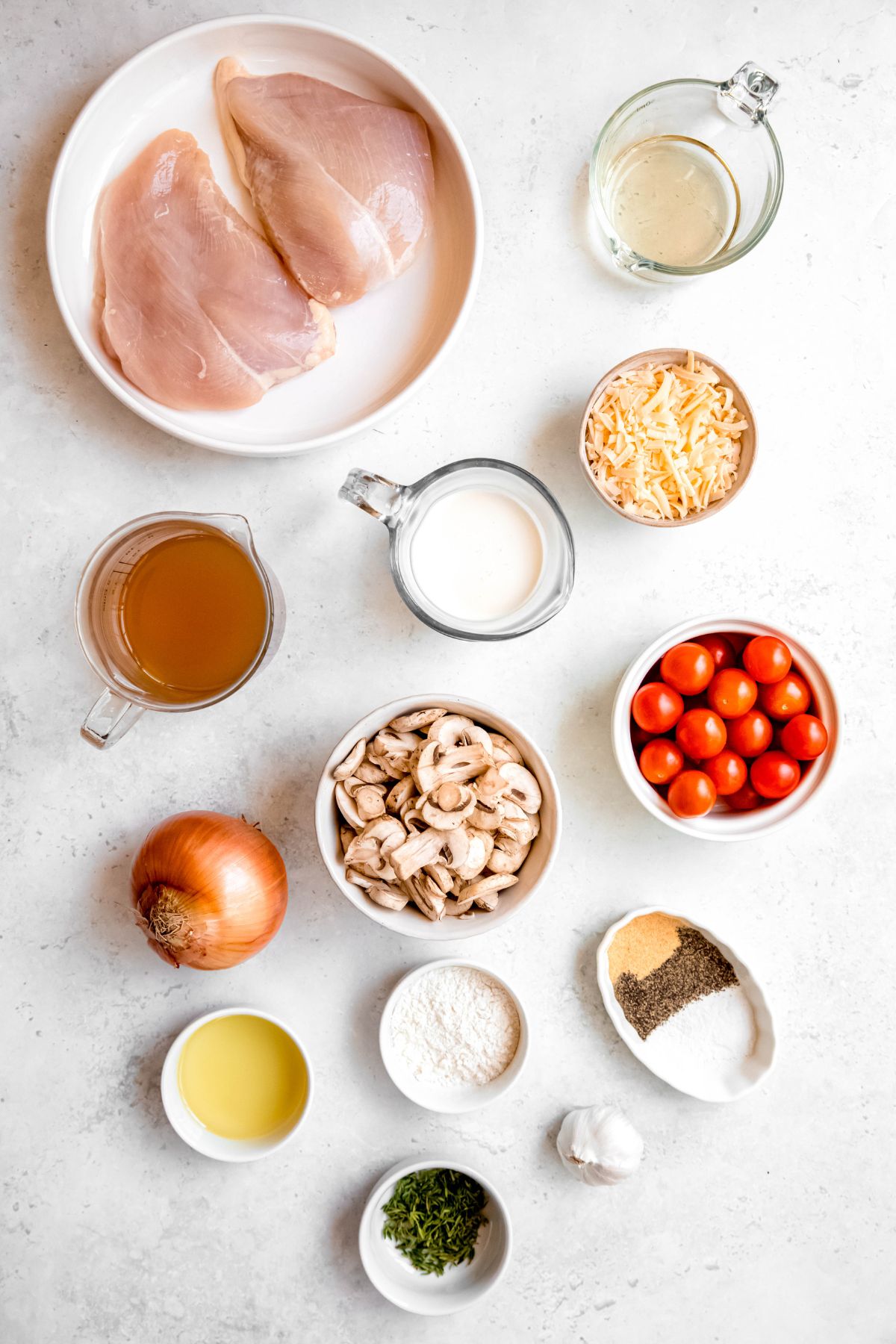 All the ingredients needed to make creamy mushroom chicken with tomatoes.