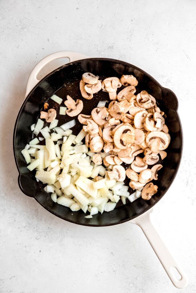 Cooking the onions and mushrooms in a skillet.