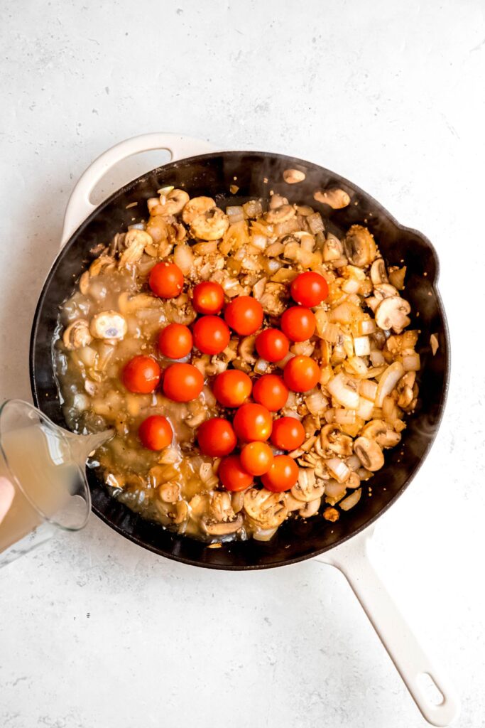 Adding tomatoes and broth to the onion and mushroom mixture.