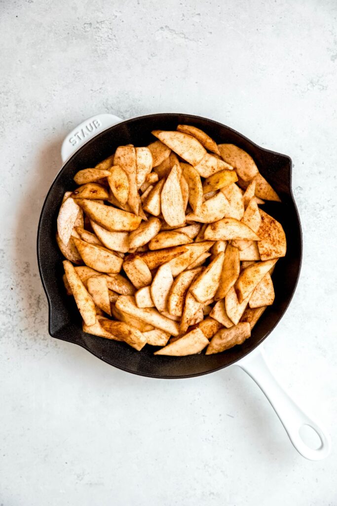 pear crisp filling in a buttered cast iron skillet.
