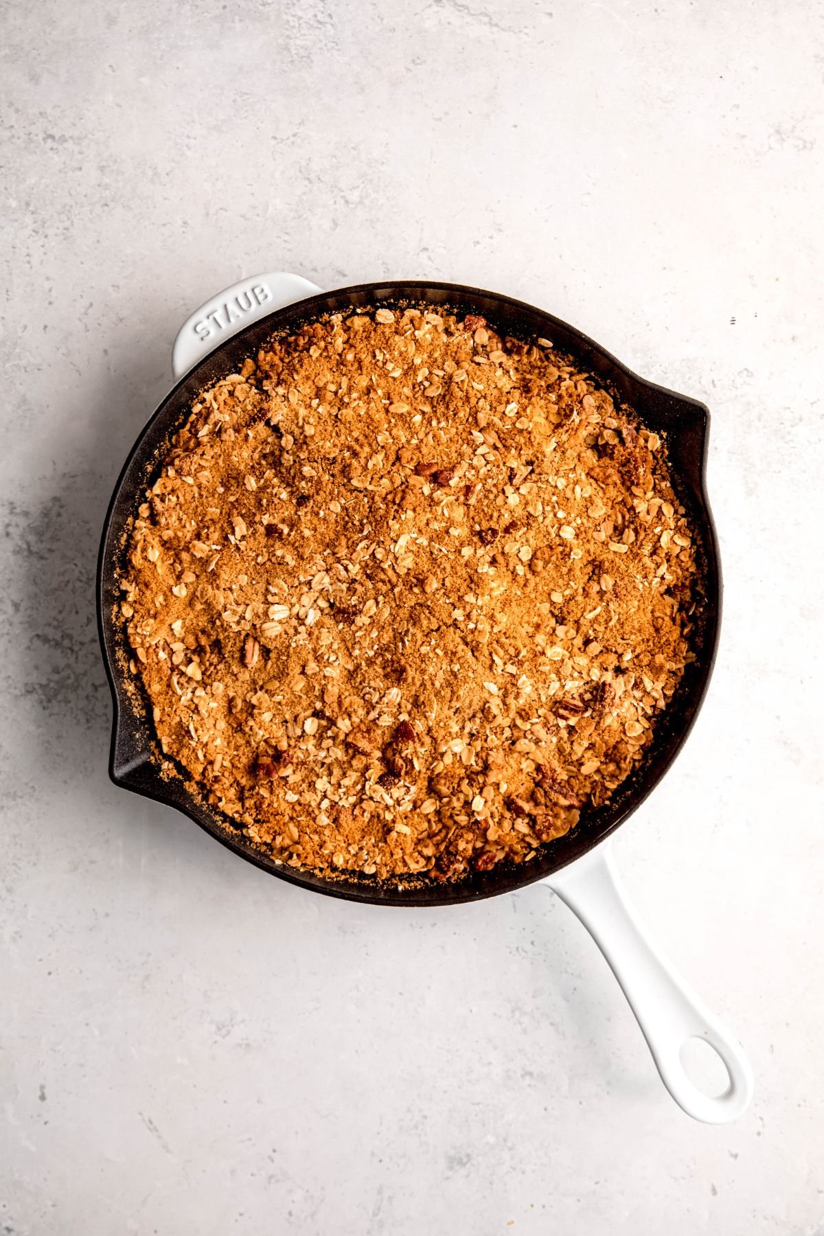 baked pear crisp on a white table cooling.