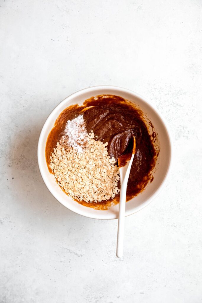 oats, baking soda, and seasonings added to the bowl with the pumpkin mixture.