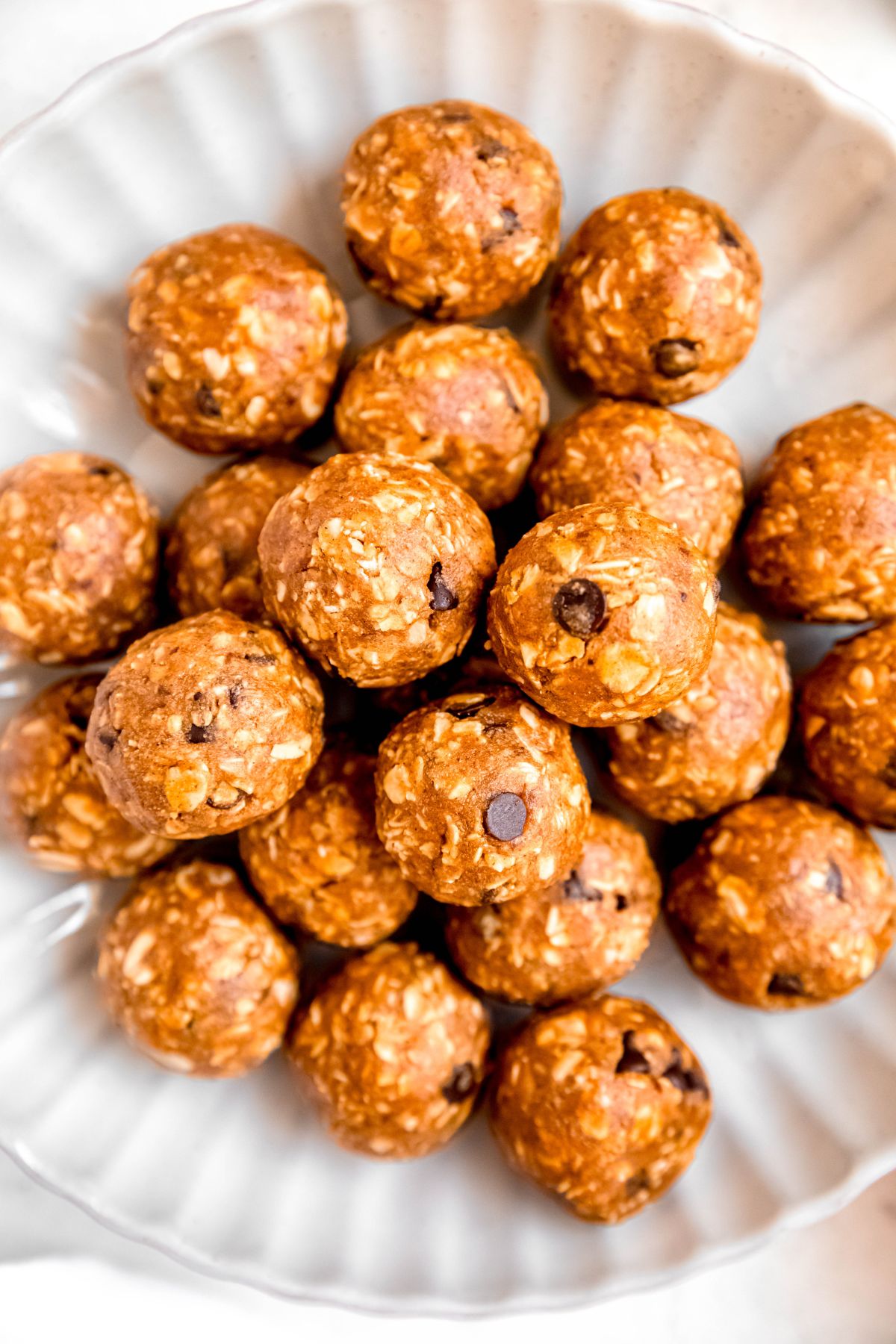 closeup overhead shot of a bowl of homemade pumpkin protein balls with chocolate chips and oats.
