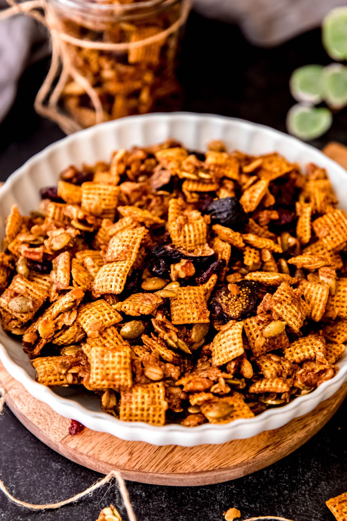 white serving bowl filled with homemade pumpkin spice chex mix for fall.