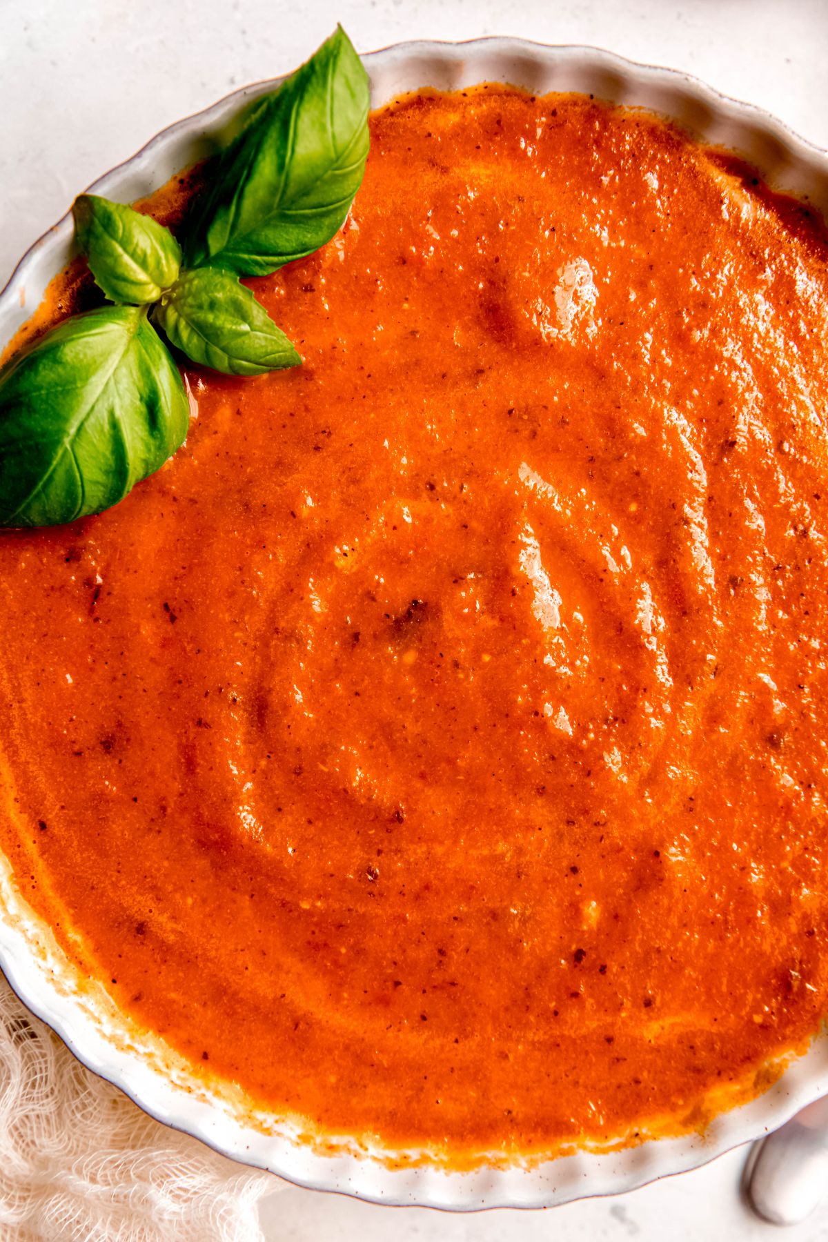 overhead shot of fresh roasted tomato basil soup showing the creamy texture.