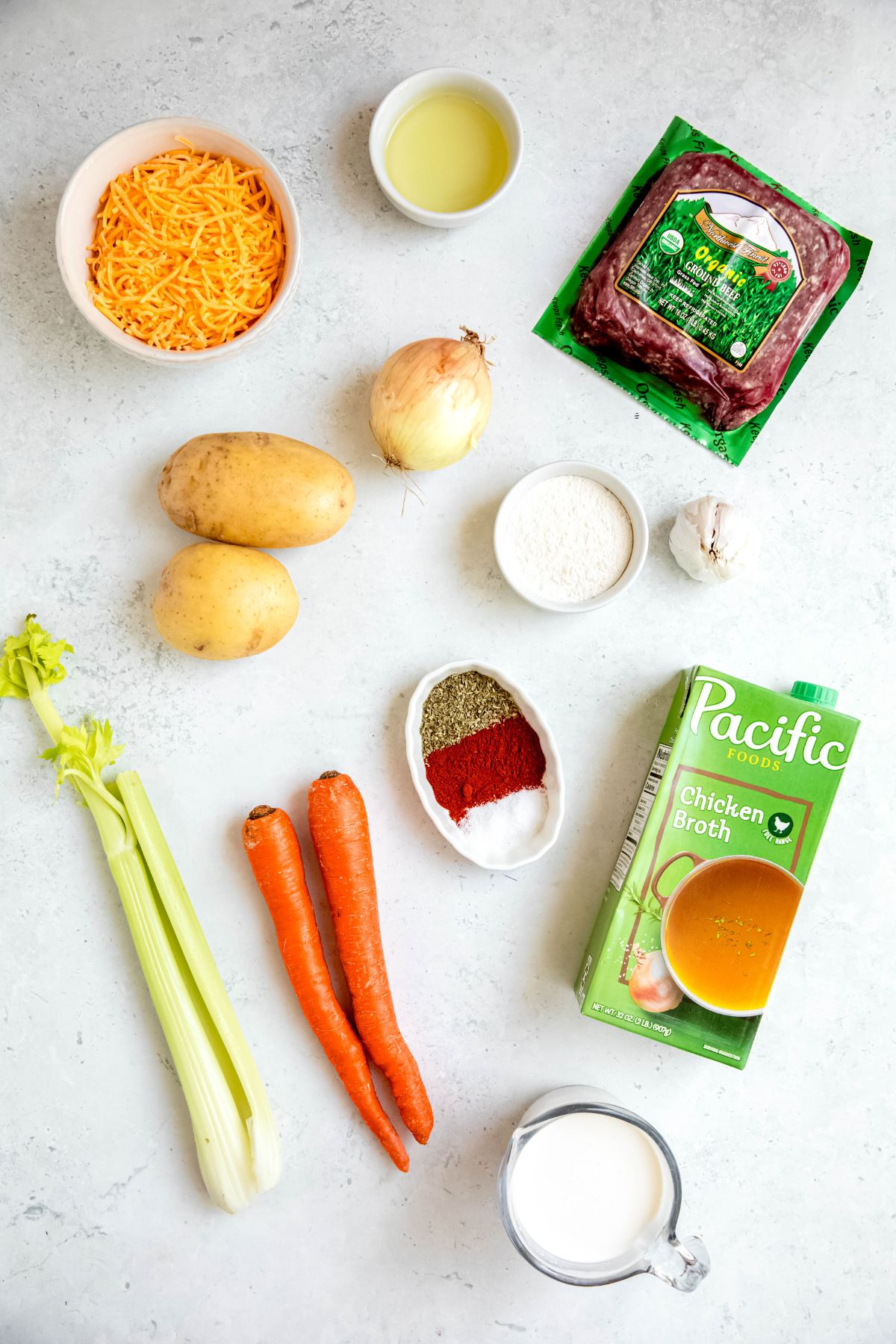 ingredients needed to make easy cheeseburger soup recipe measured out on a white table.