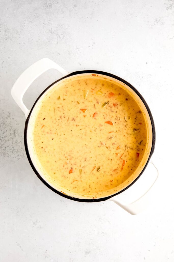 dutch oven filled with creamy cheeseburger soup after stirring in all the dairy.