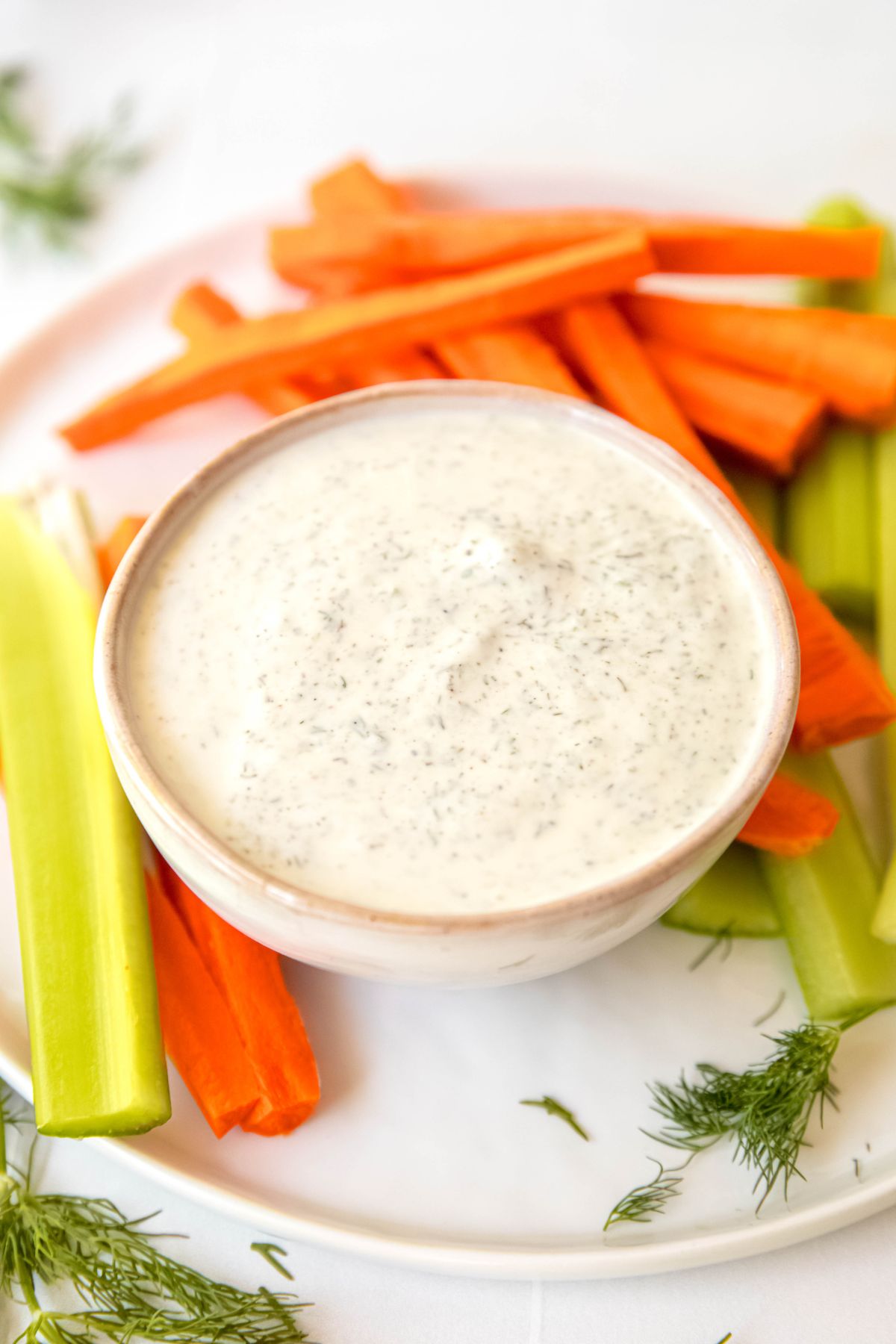 A close-up angled shot of a small dish of homemade Greek yogurt based salad dressing.