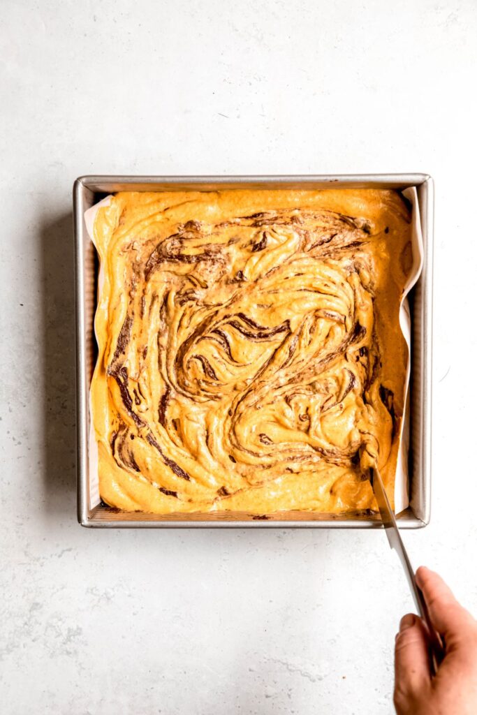 Swirling the pumpkin brownie topping before baking.