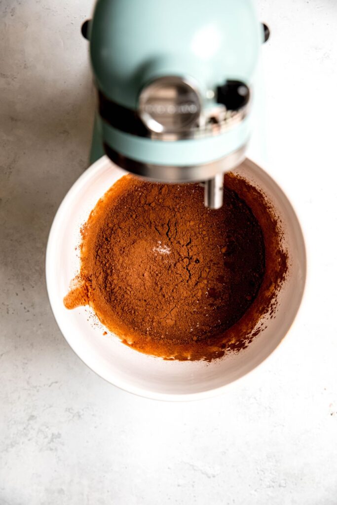 An overhead shot of a stand mixer with after adding the cocoa powder to the brownie batter.