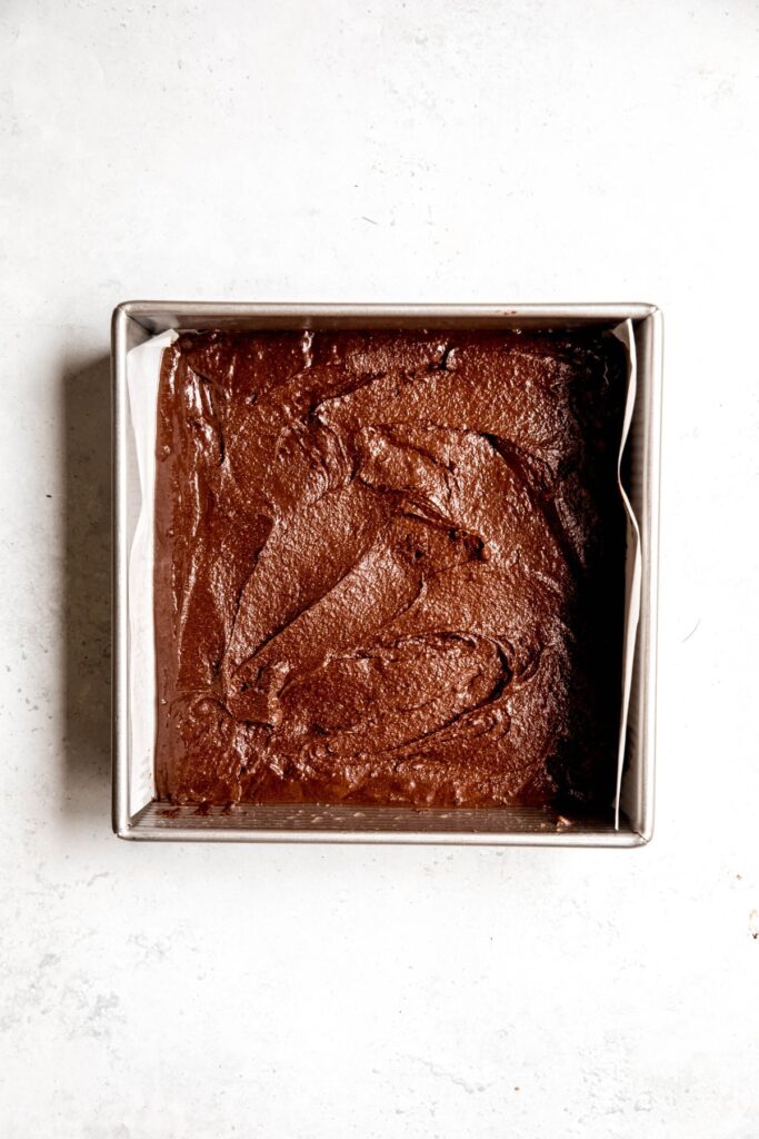 An overhead shot of an 9x9-inch baking pan filled with brownie batter.