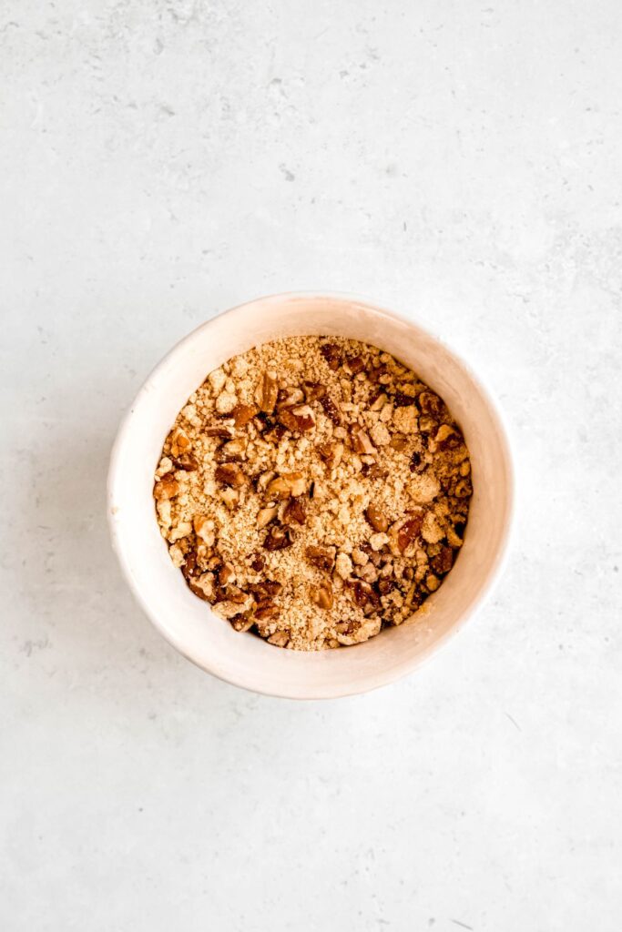 portion of the crust mixture set aside for the crumb topping after mixing with chopped pecans.