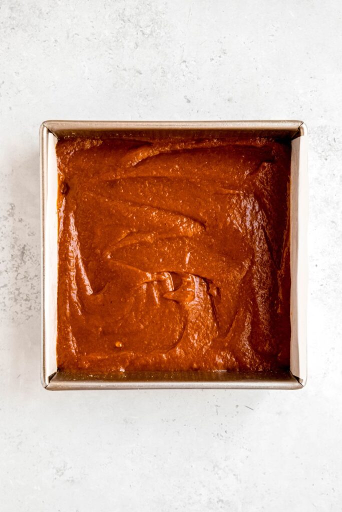 pumpkin pie filling poured on the raw crust and smoothed out.