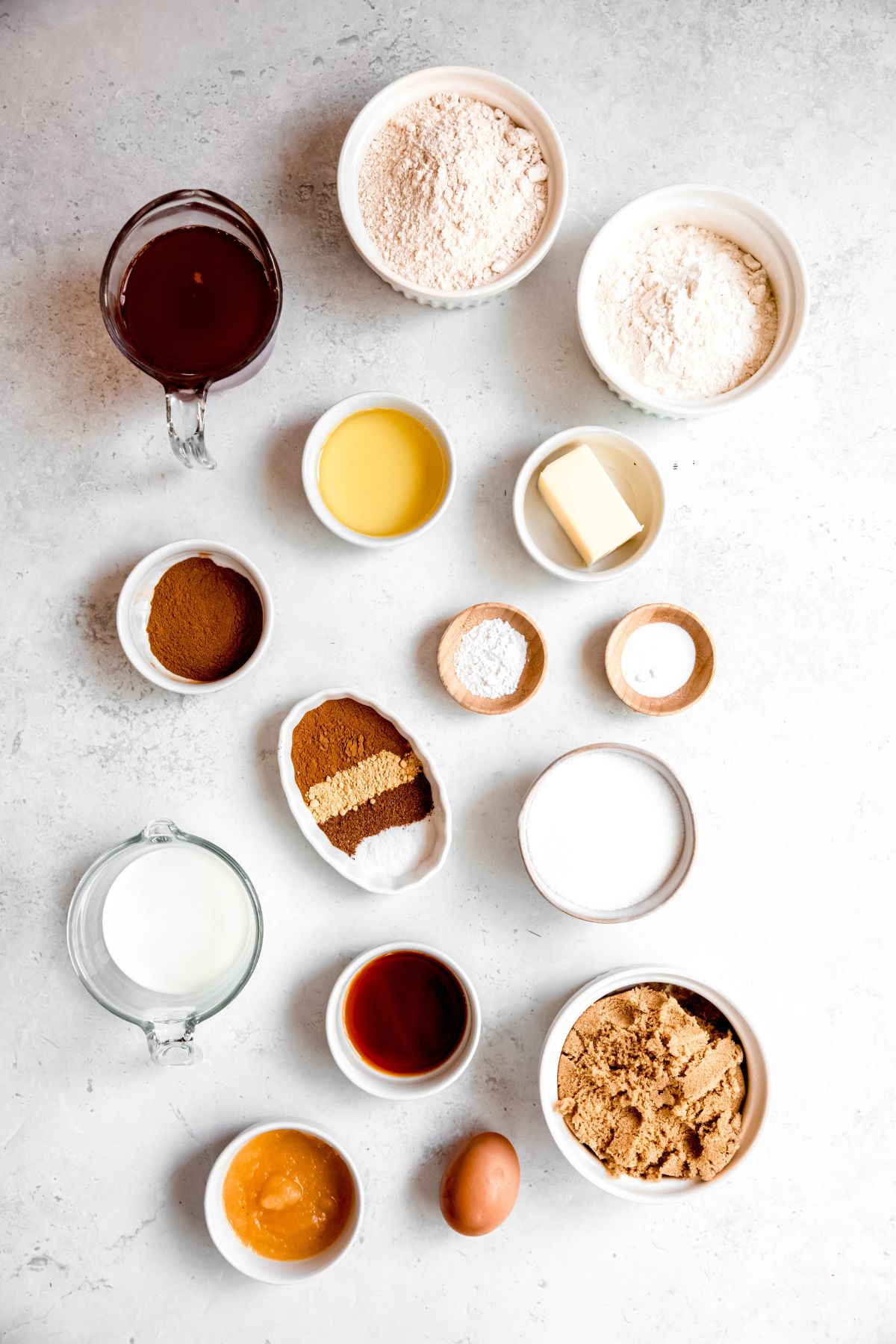 ingredients needed to make baked apple cider donuts recipe measured out on a white table.