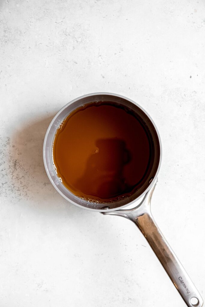 apple cider simmering in a saucepan to reduce.