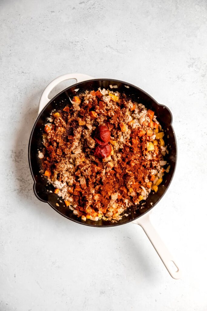 The cooked ground beef and onion mixture topped with spices.