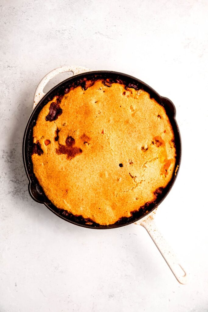An overhead shot of a skillet of baked chili cornbread casserole.