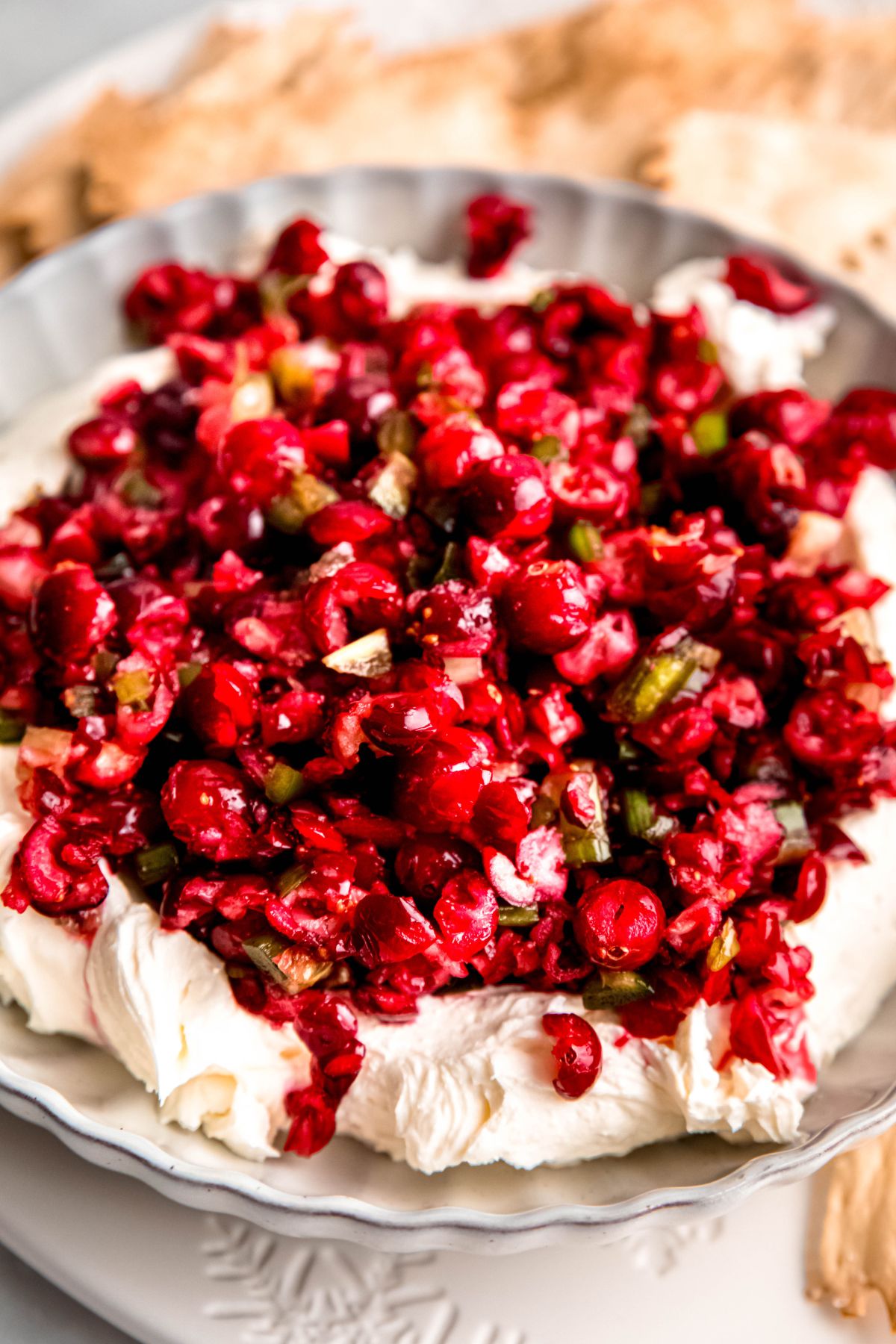 closeup shot of jalapeno cranberry dip on a bed of creamy whipped cream cheese.