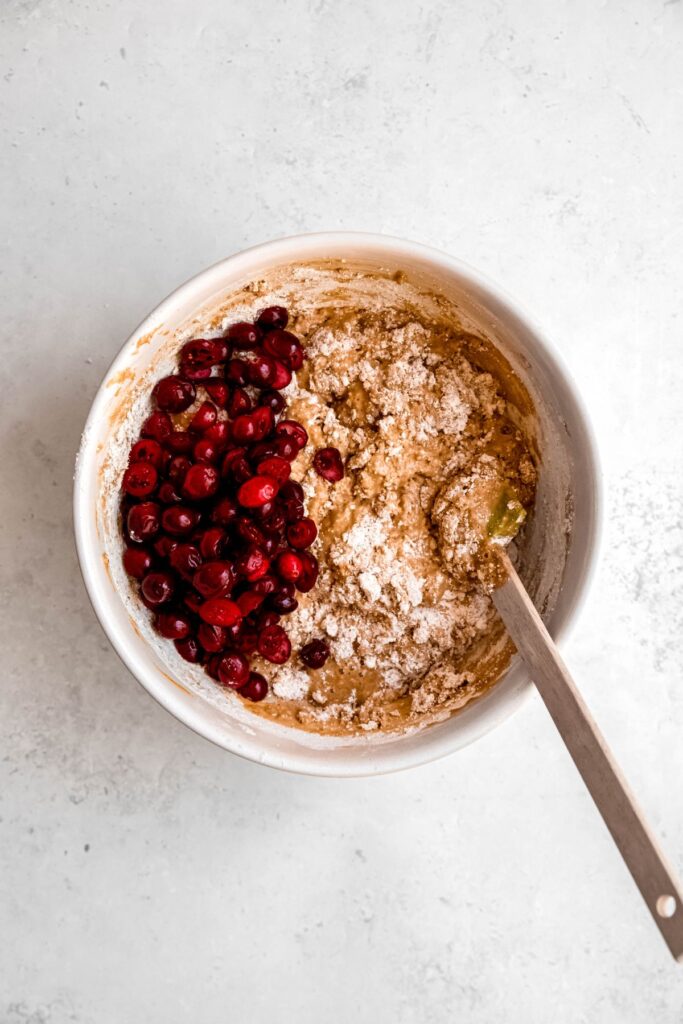 cranberries added to the bowl with the mostly mixed orange muffin batter.