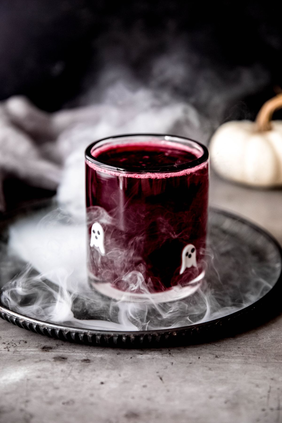 A side shot of a small glass of bubbly halloween lemonade.